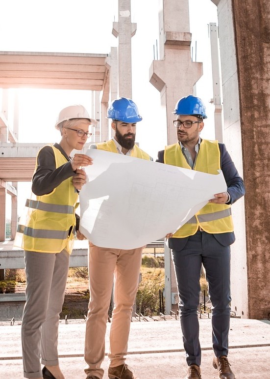 Bauingenieure, die sich auf einer Buastelle Ihren Plan angucken